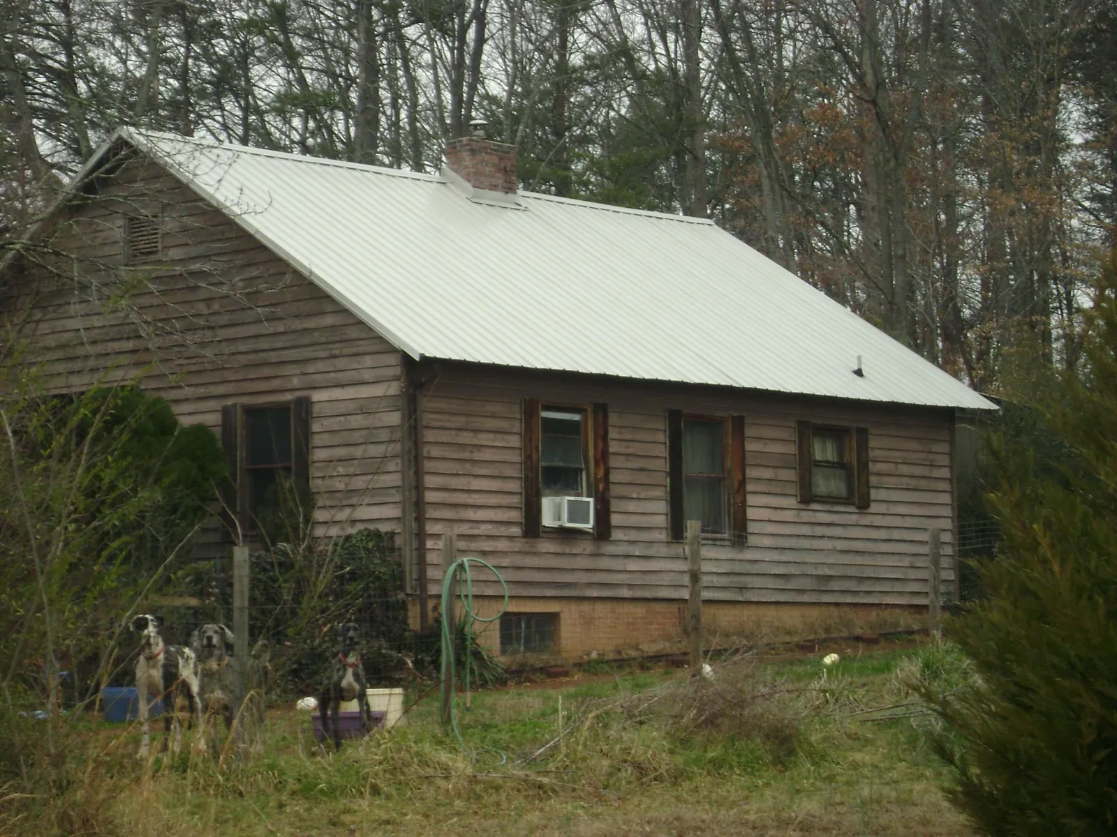 White metal roof on an old wood sided farmhouse, from a Metal Roof Installation job in Manhattan